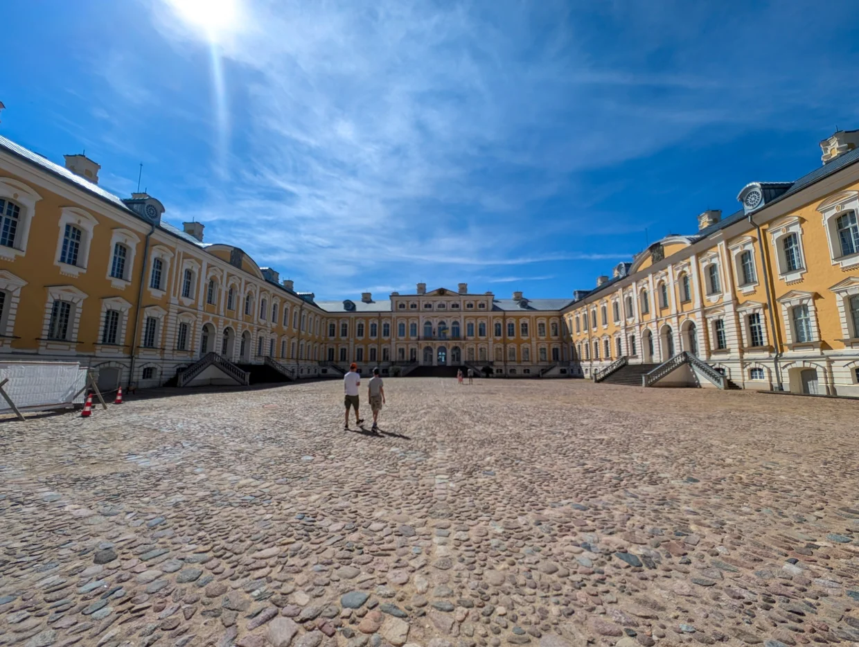 The yellow baroque facade of Rundāle Palace across its cobbled courtyard
