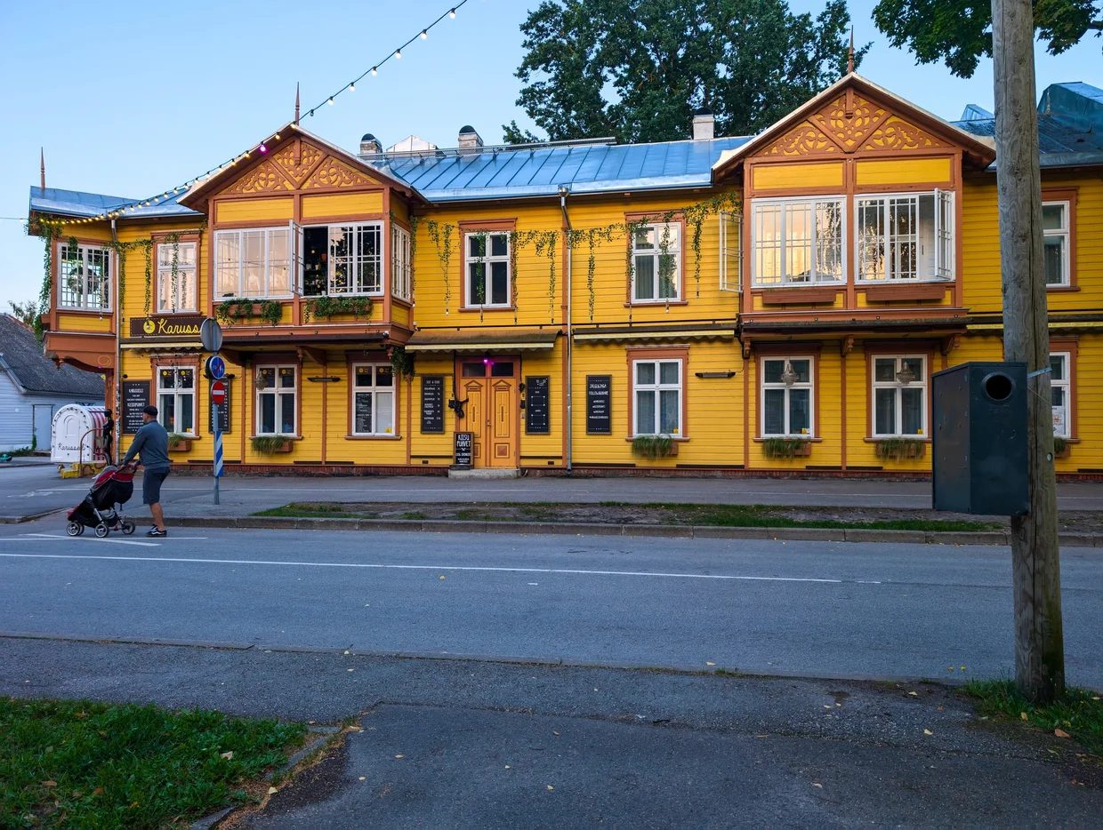 Bright yellow wooden villa on a Pärnu street, possibly the Raua guesthouse