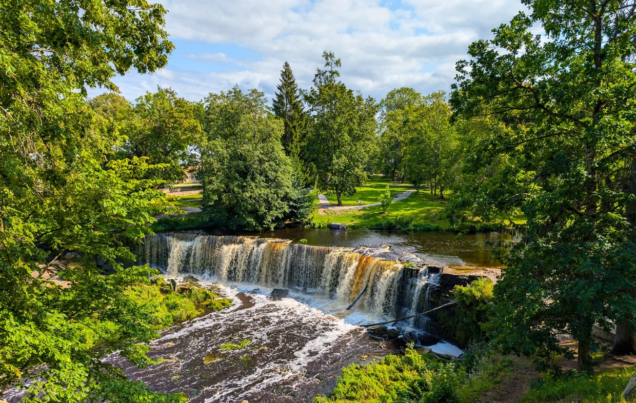 Keila-Joa waterfall, broad and stepped, falling into a wooded gorge