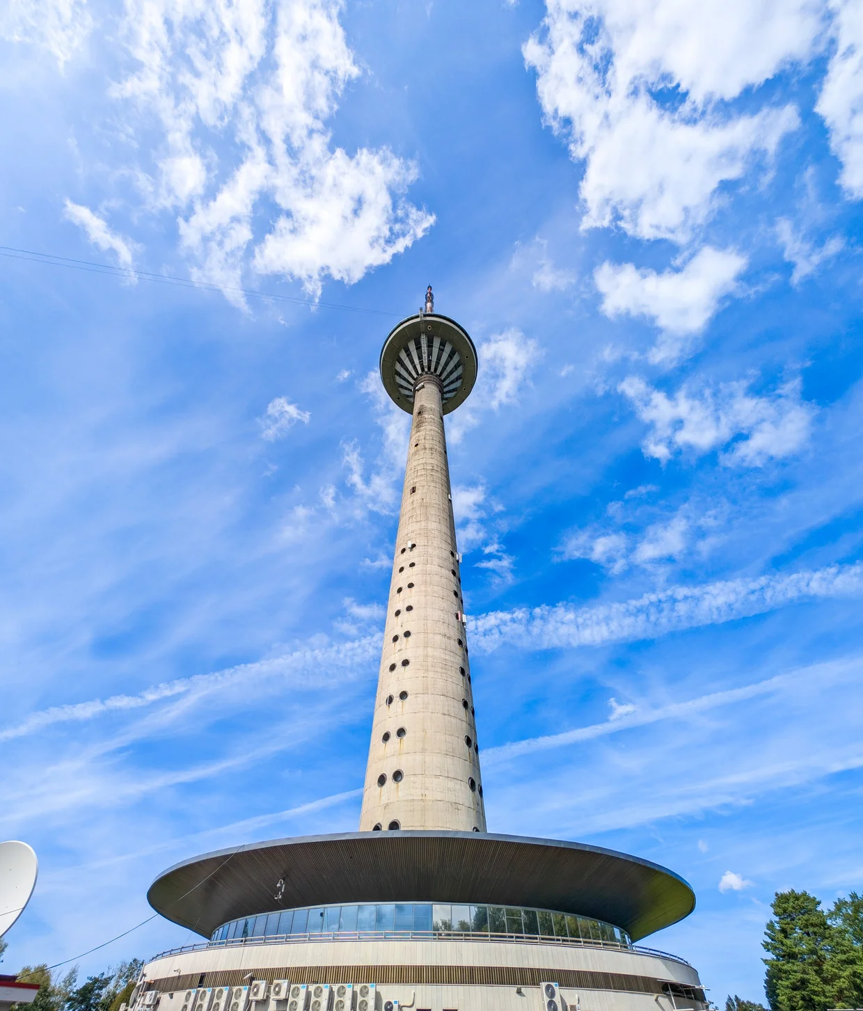 Tallinn TV Tower rising against a cloudy blue sky, saucer-shaped top