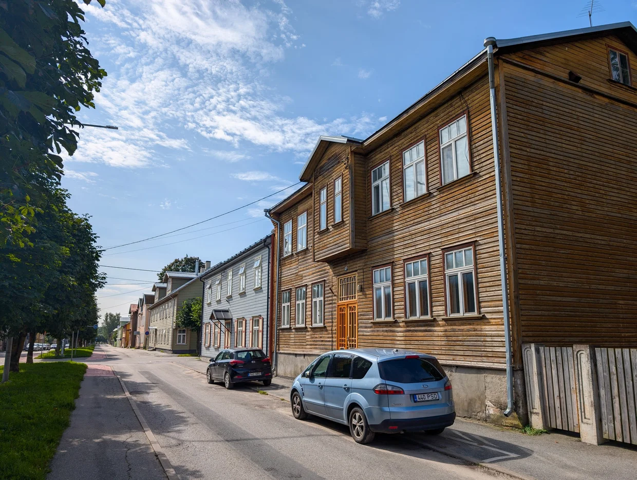 Wooden Tartu house painted warm brown with tall windows on a sunny street