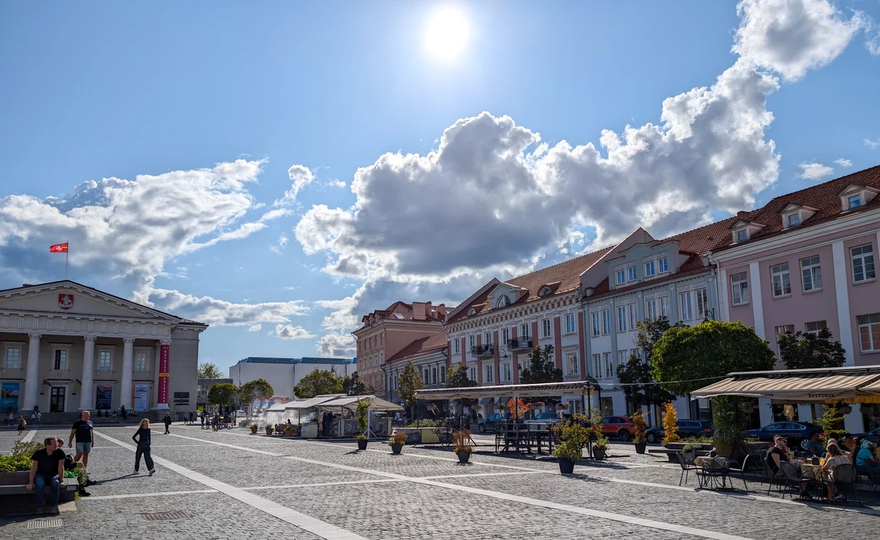 Town Hall Square in Vilnius, sun overhead, cafes lining the square