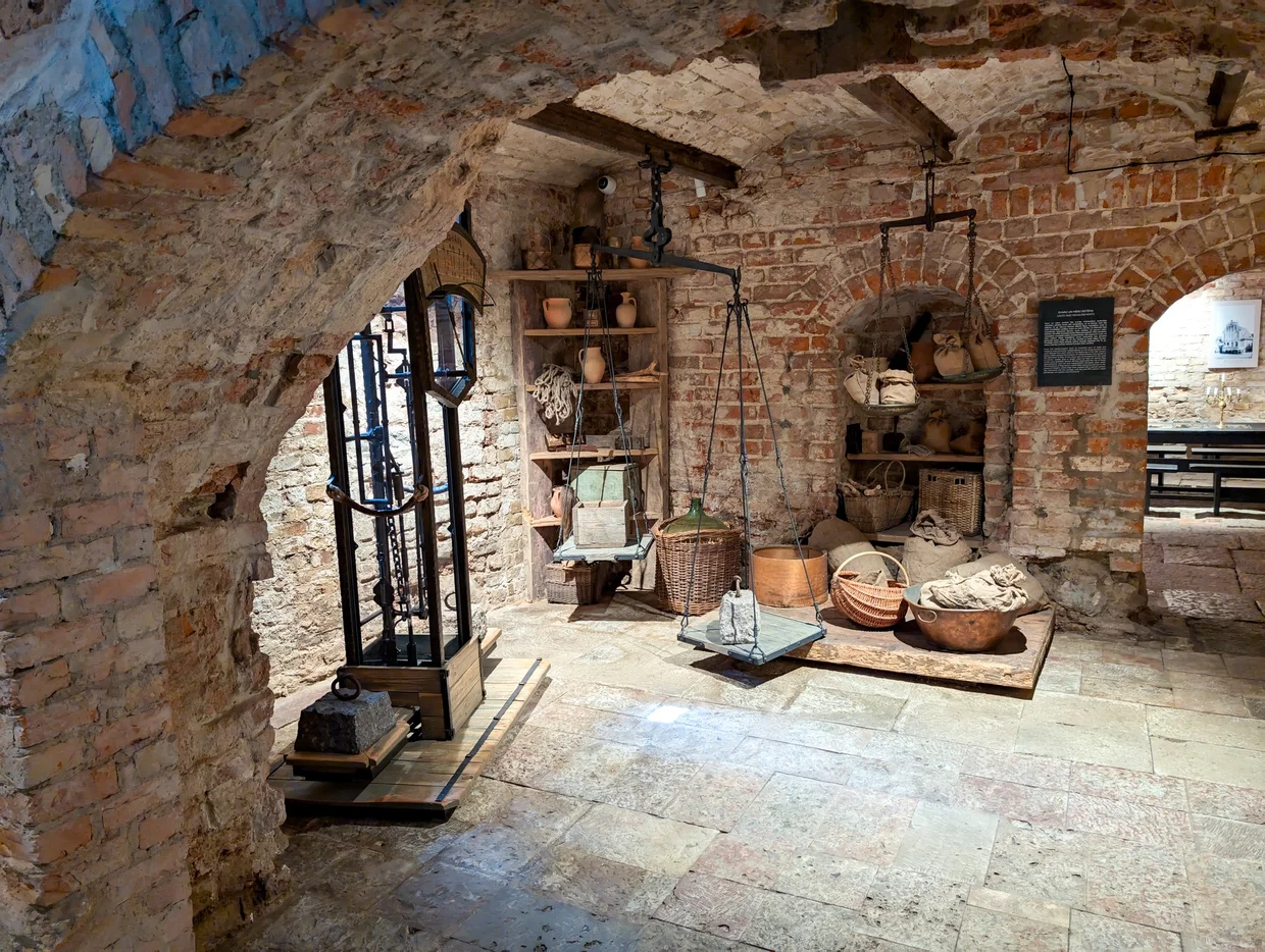 A medieval vaulted cellar with wooden beams and old artifacts