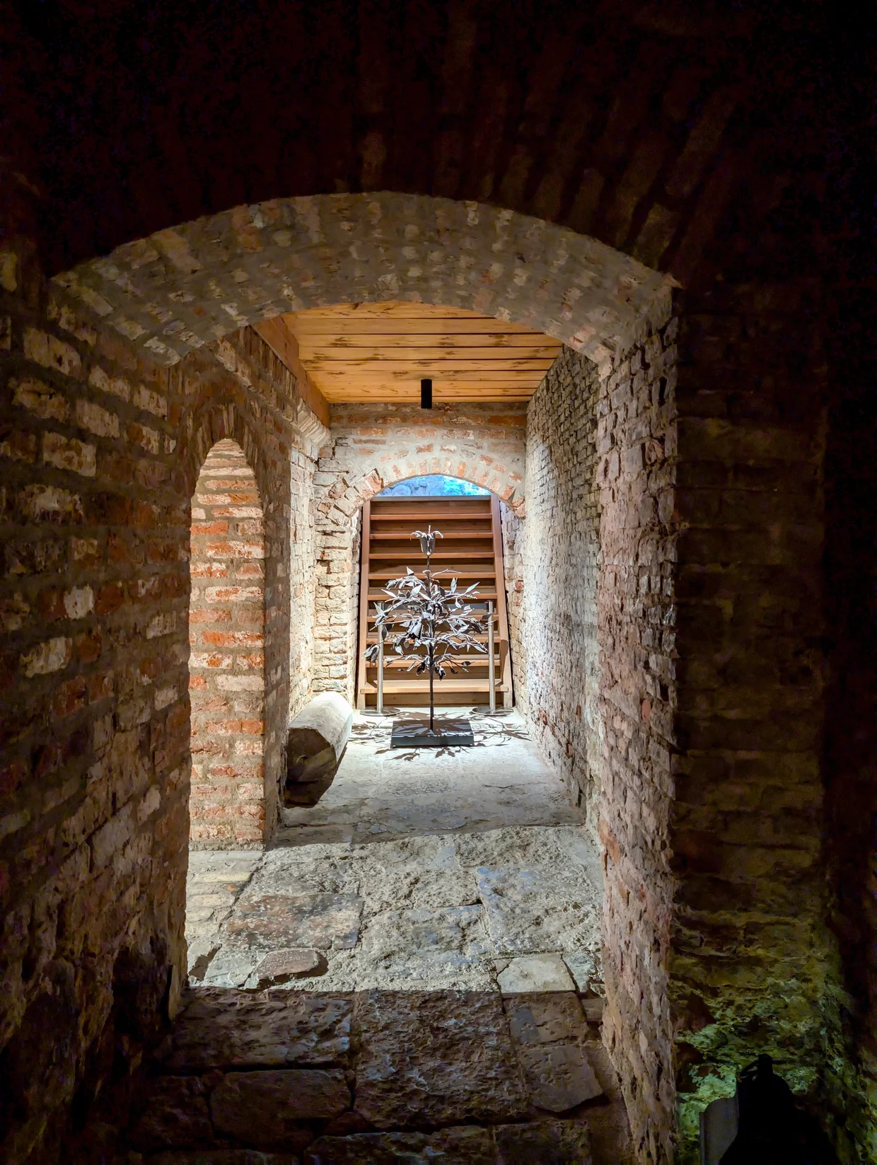 A dimly lit stone passage under brick arches in a medieval Riga building