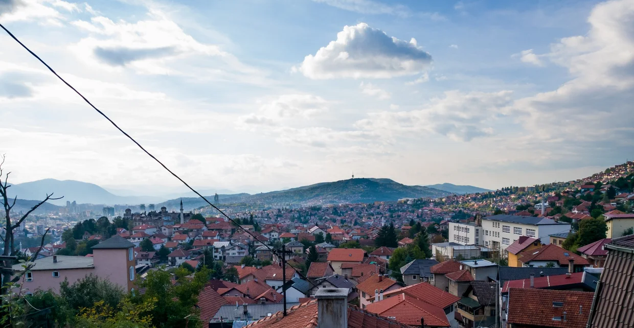 Sarajevo seen from the surrounding hills, red rooftops filling the valley between mountains