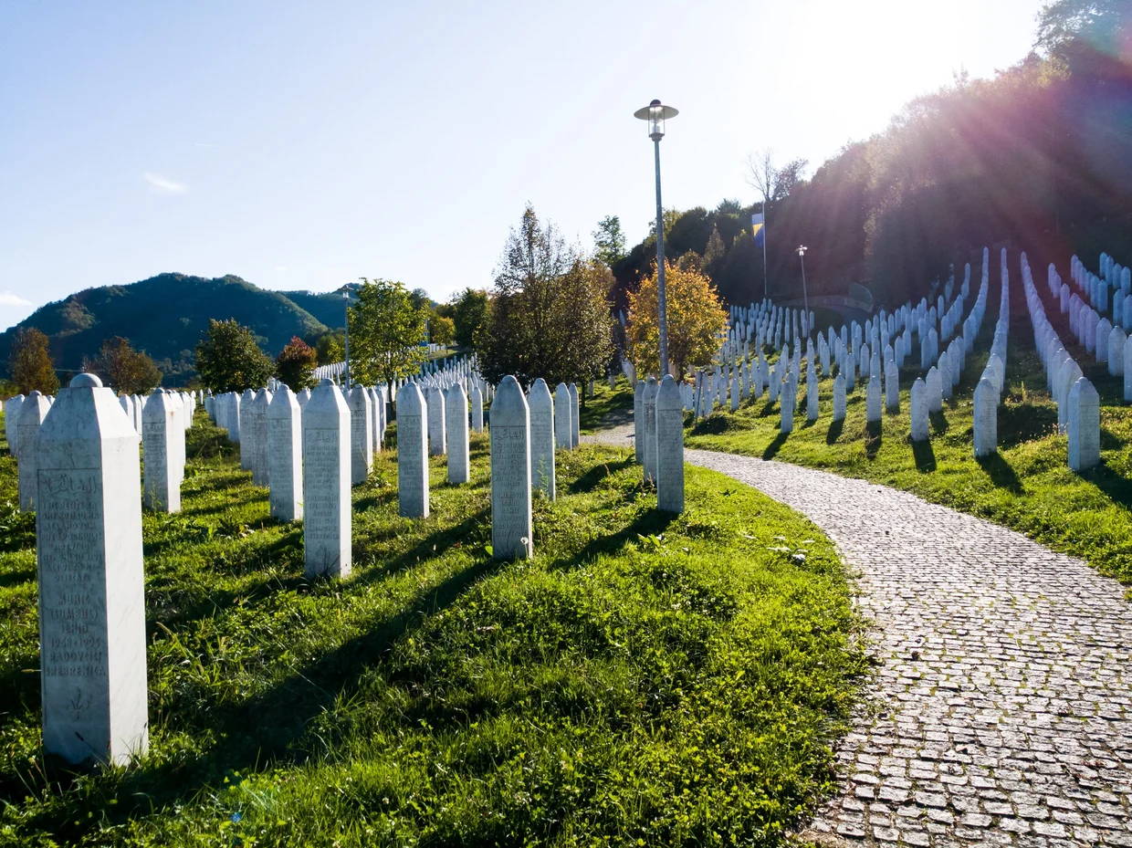 Srebrenica Memorial, rows of white headstones stretching across a green hillside
