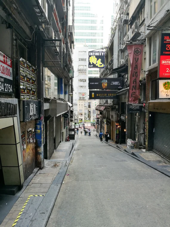 Narrow back alley in Hong Kong with signs for bars and restaurants