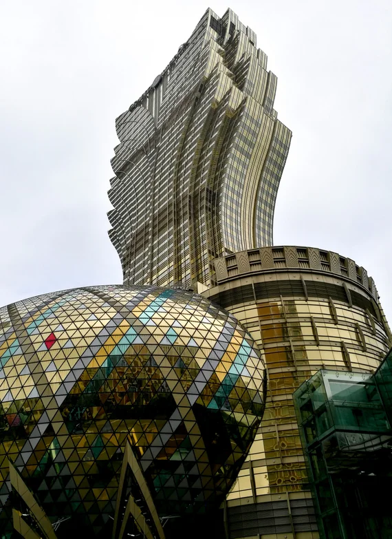 Grand Lisboa casino building towering over Macau at night