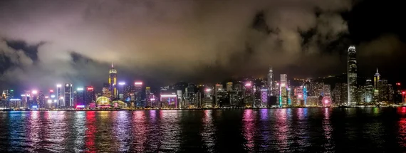 Panoramic night view of Hong Kong Island skyline reflected in Victoria Harbour