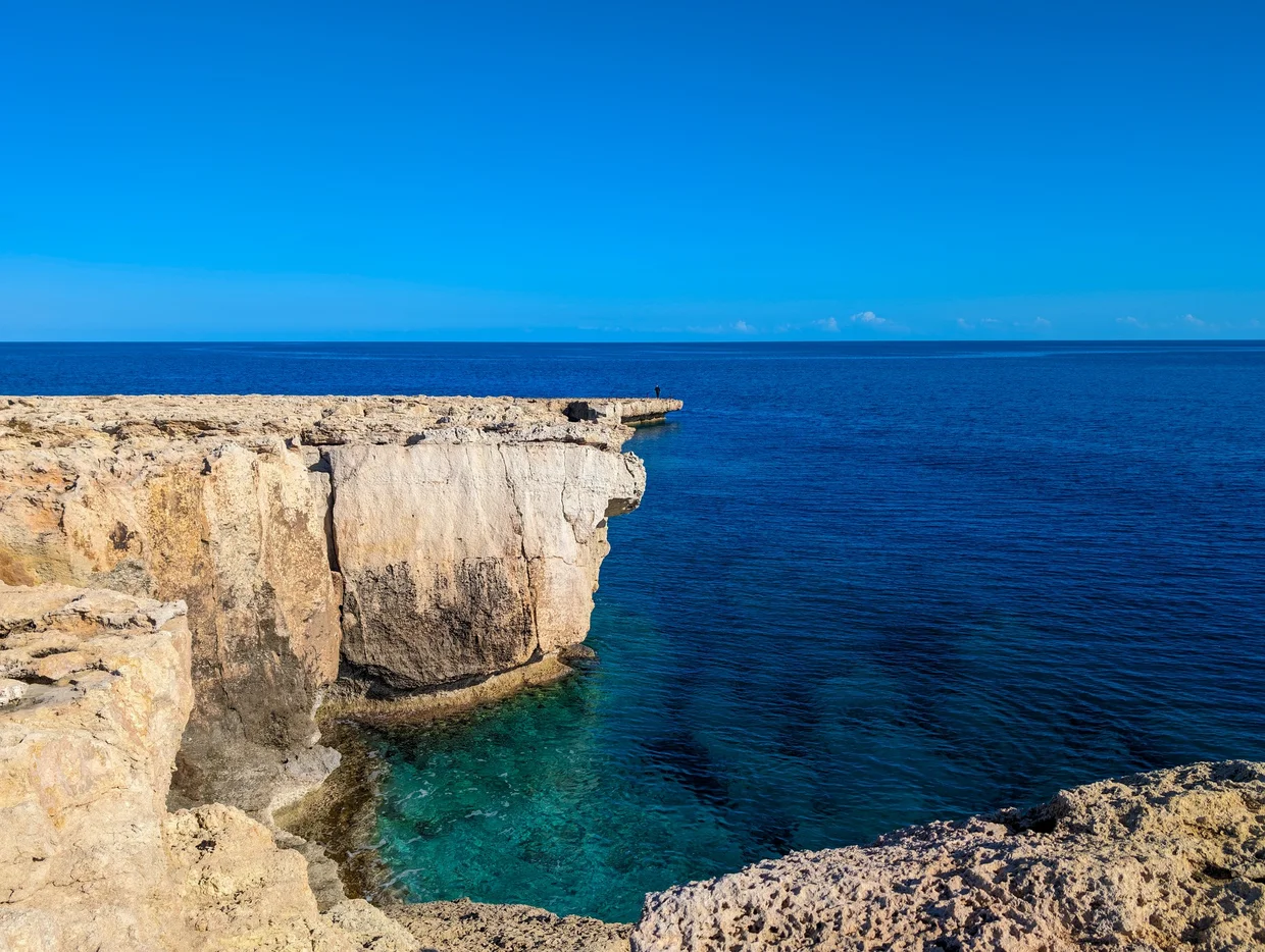 Dramatic limestone sea cliffs dropping into deep blue water