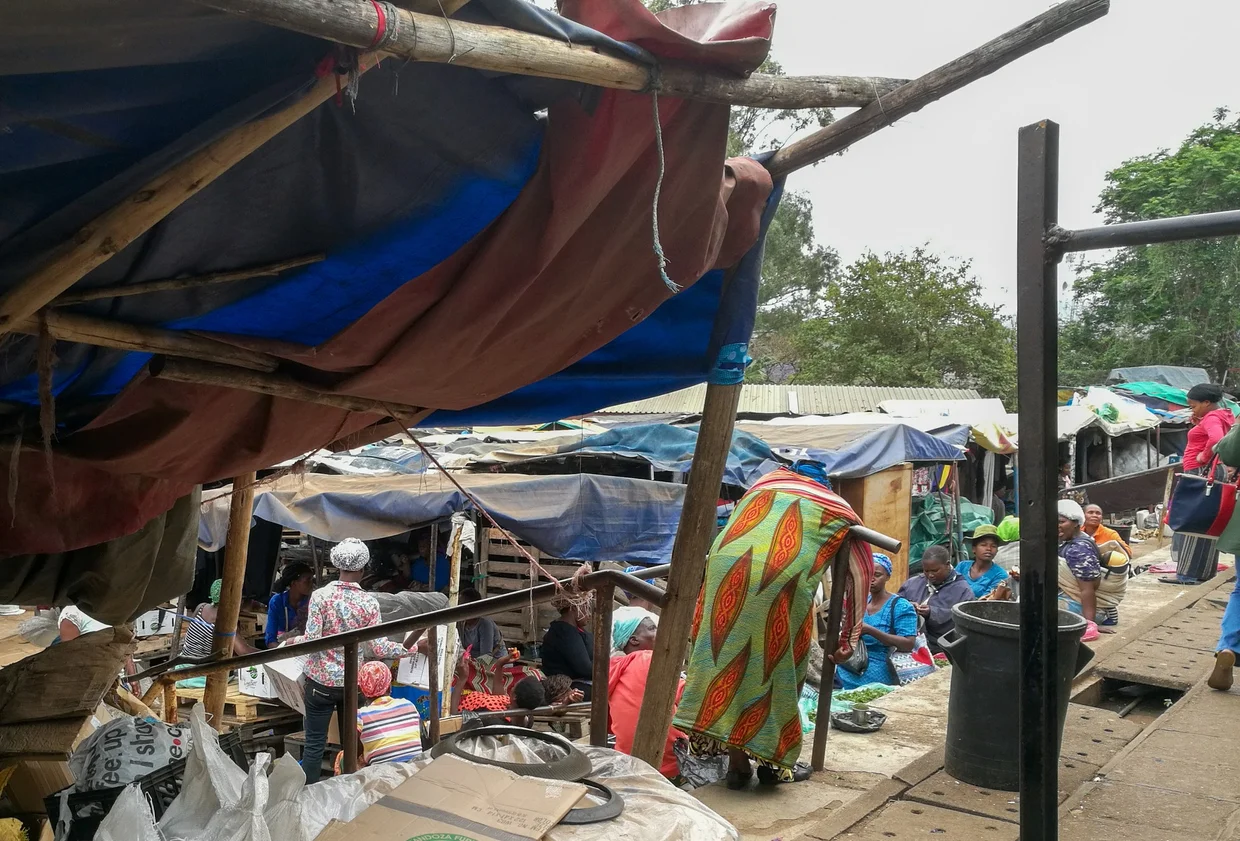 Busy open-air market in Eswatini with tarpaulin shelters and vendors