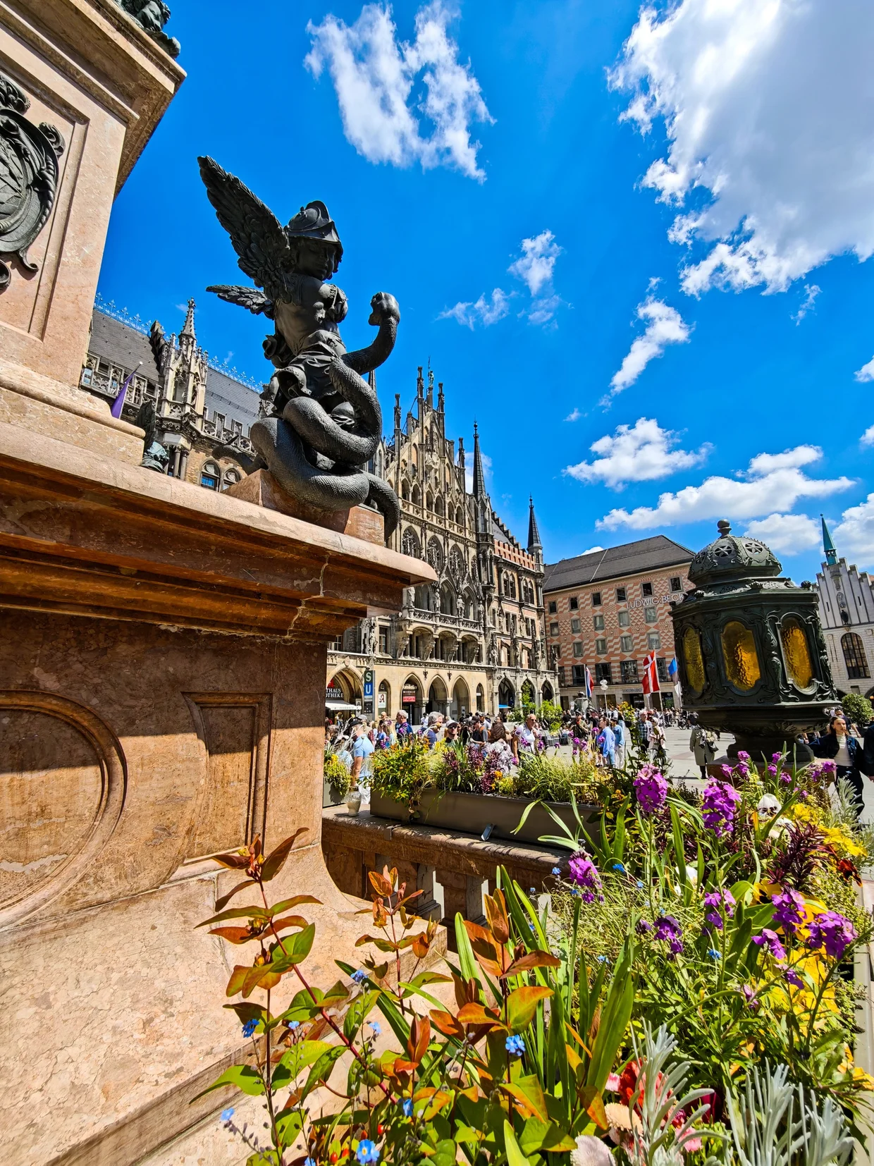 Marienplatz framed by the Mariensäule angel statue and seasonal flowerbeds