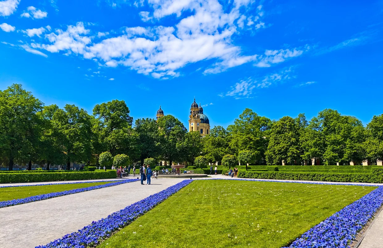 Hofgarten path looking towards the Theatinerkirche towers through the trees
