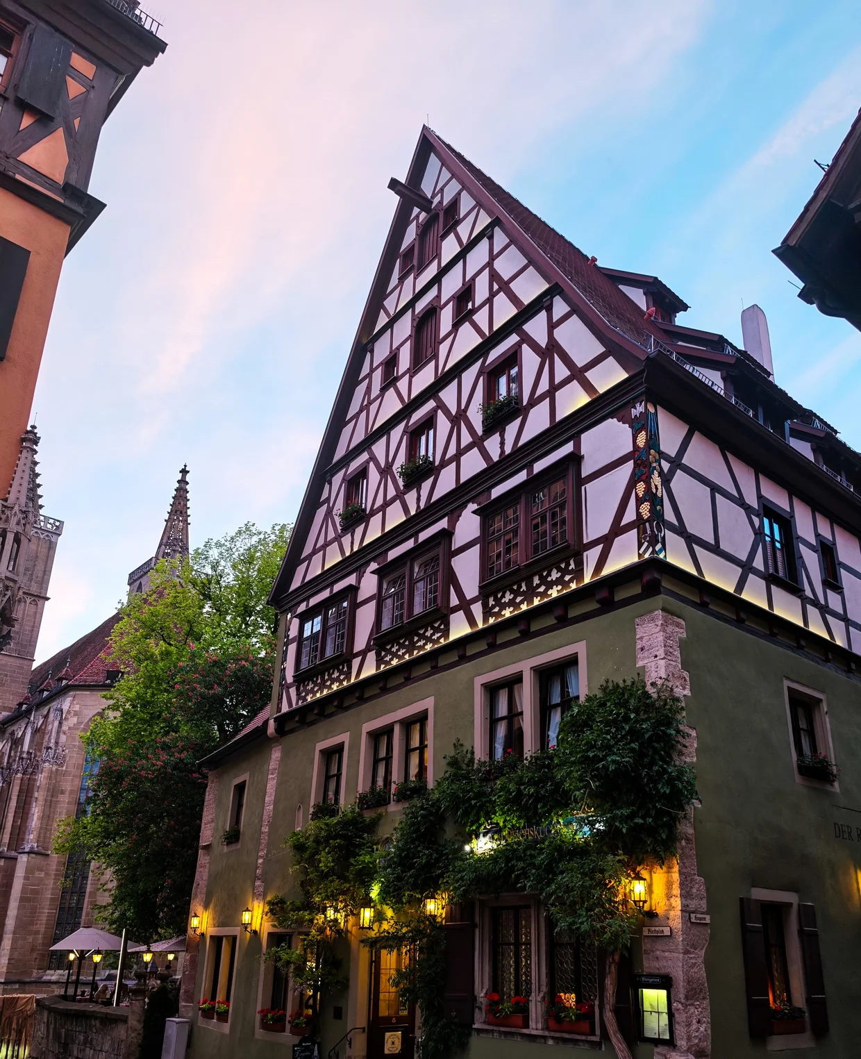 A half-timbered hotel lit warmly at dusk