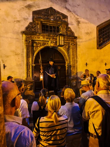 The night watchman with cape, lantern, and halberd at one of the tour's stops