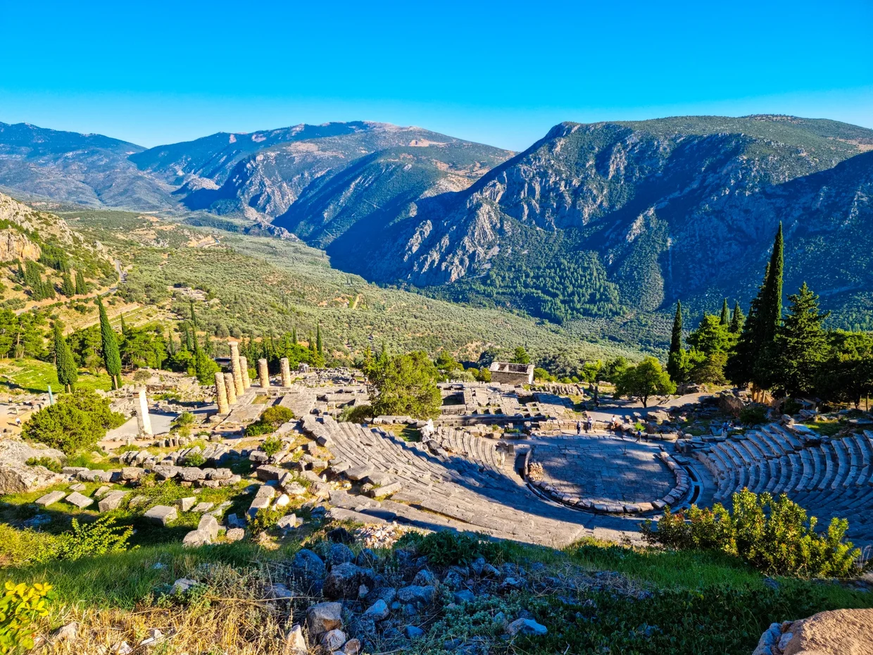 Ancient theater of Delphi carved into the hillside with panoramic mountain views