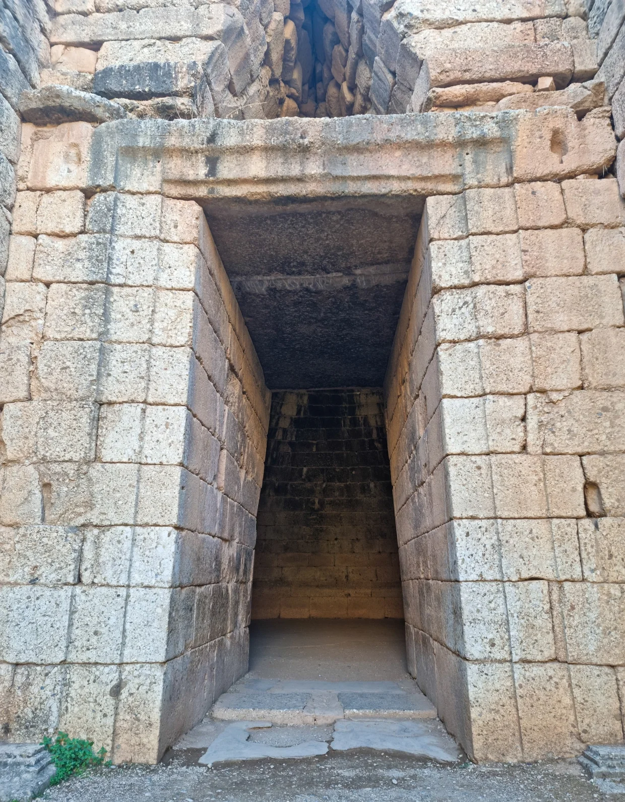 Massive stone entrance to the Treasury of Atreus with a towering lintel block