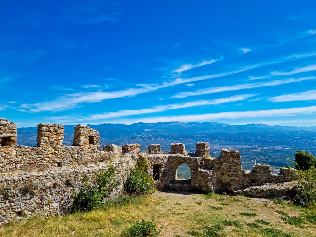 Fortress walls of Mystras at the summit with distant mountains