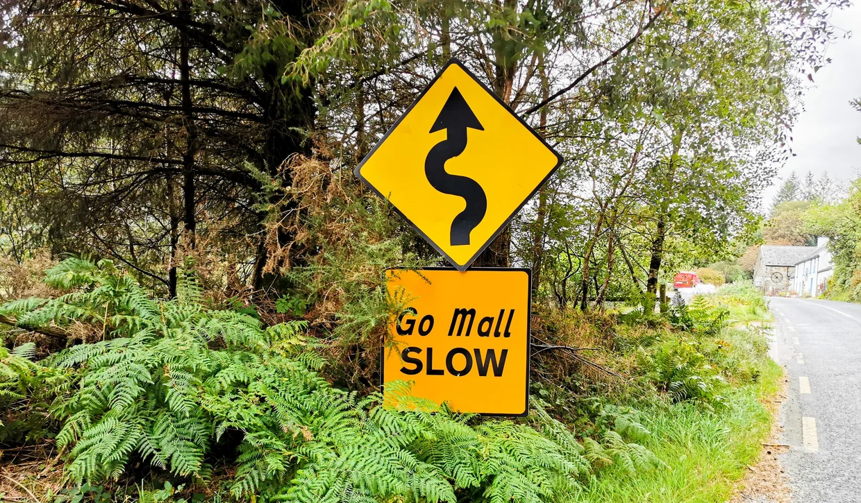 Go Mall / Slow road sign in Irish and English on a narrow country road