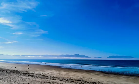 Wide sandy beach stretching toward distant mountains