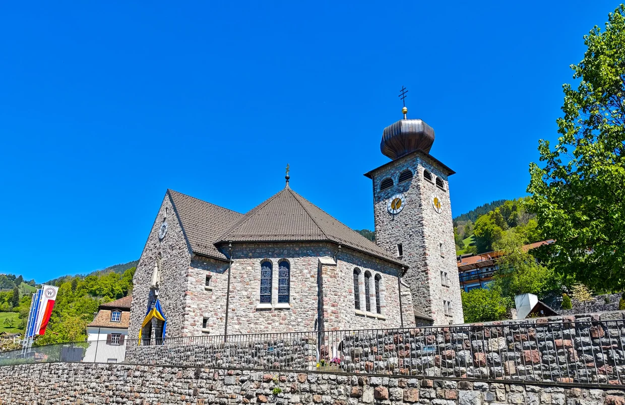 Same church from a different angle, with the stone wall and a flag