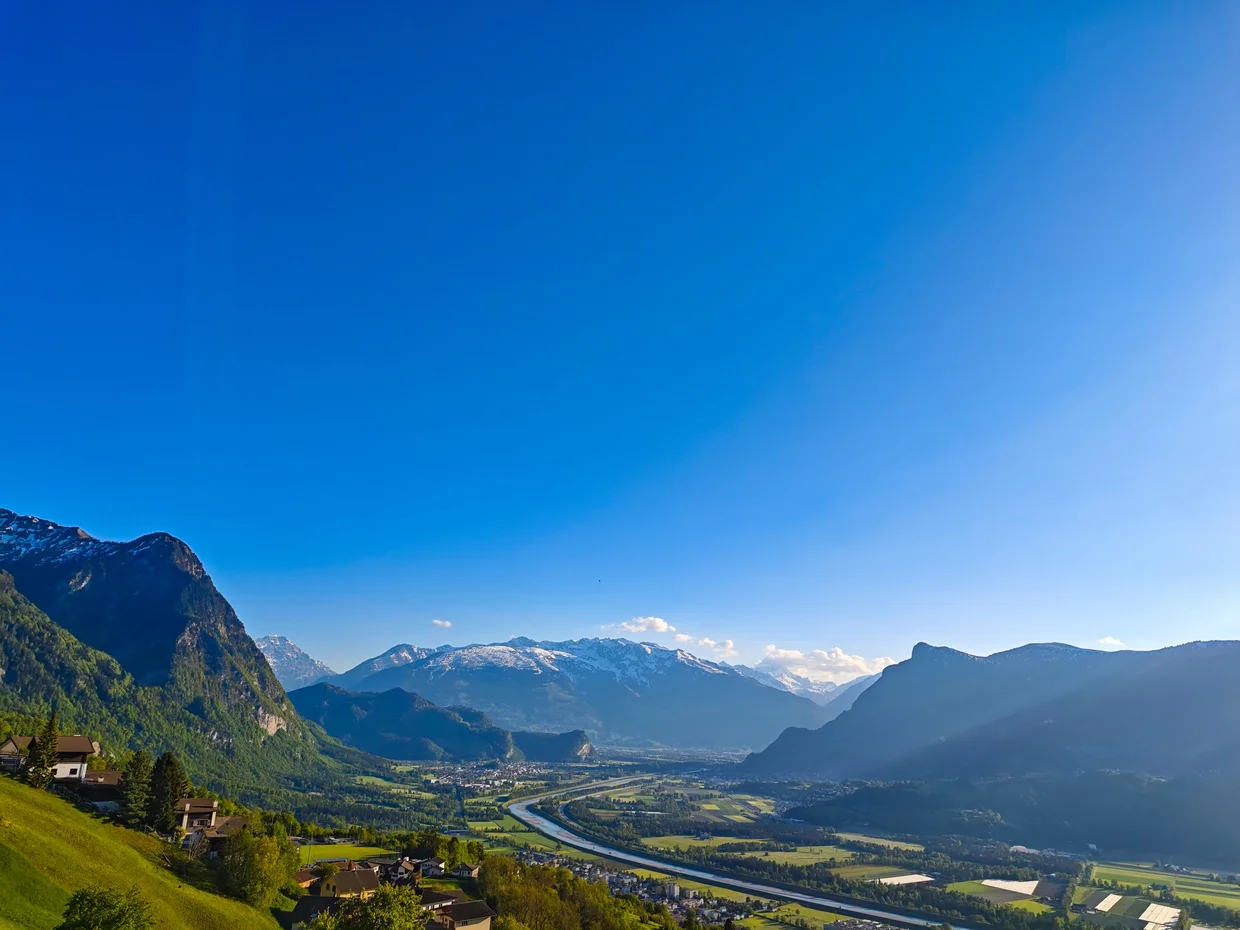 Same view in early evening light, with the Alps softening into haze