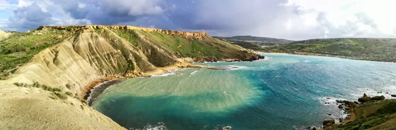 Wide panoramic view of the curved sandy beach from above
