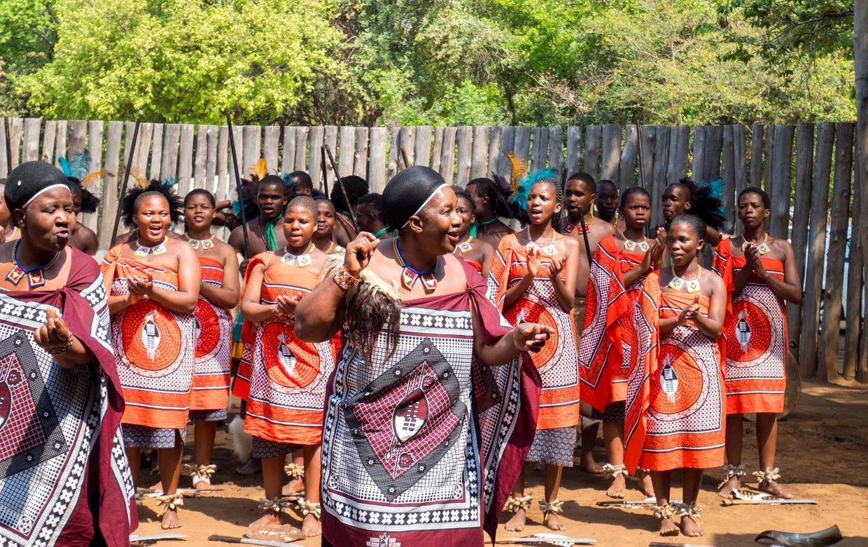 Traditional Swazi dancers in colorful dress performing at Mantenga Cultural Village