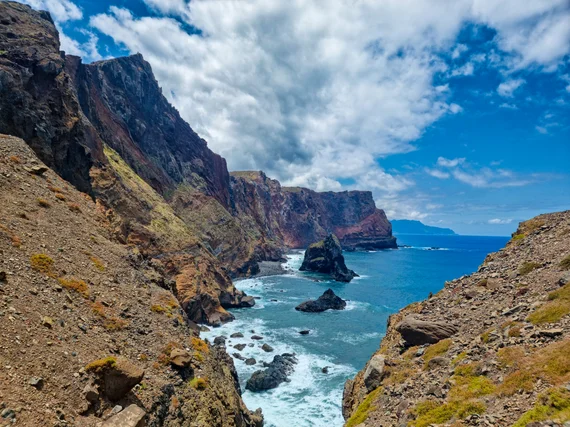 Dramatic volcanic cliffs and sea stacks with waves crashing below