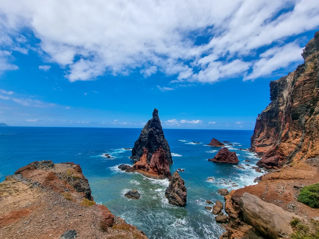 Volcanic sea cliffs and rock pinnacle rising from turquoise waves at Ponta de São Lourenço