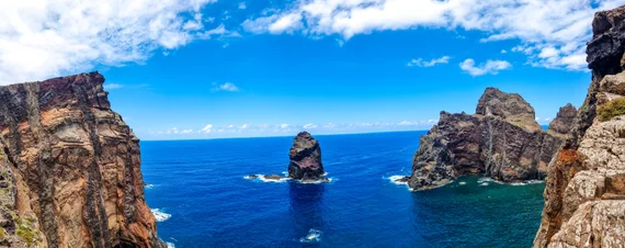 Panoramic view through a rock gap to a sea stack in the deep blue Atlantic
