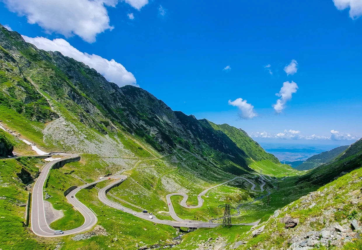 Hairpin bends on the Transfăgărășan road above green valleys