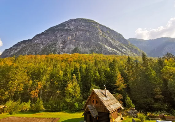 Small wooden hut below a rounded mountain