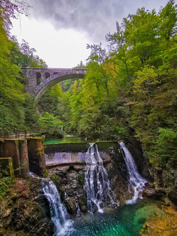 Waterfall and pool with a stone bridge above