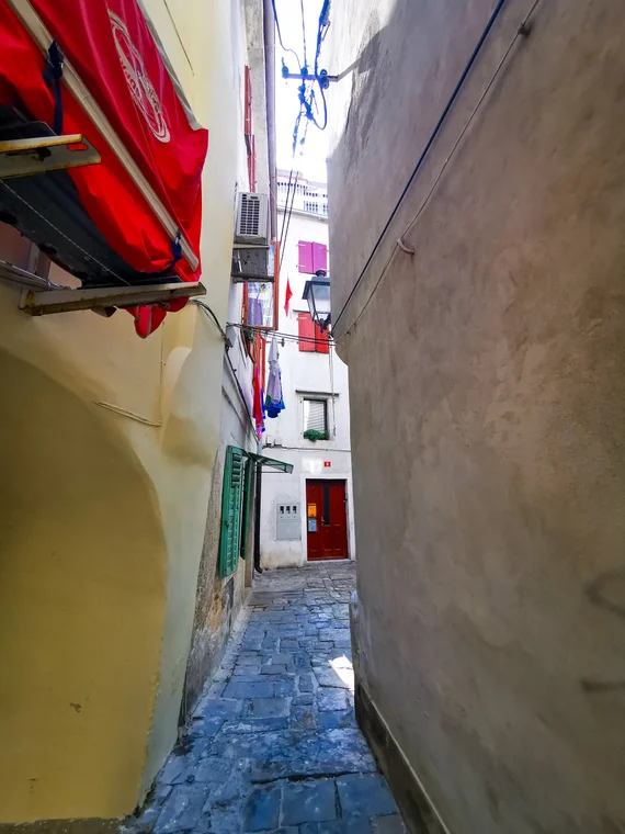 Very narrow colorful alley between tall walls
