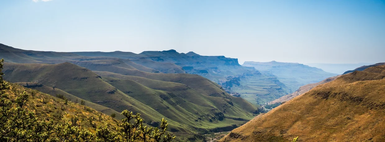 Panoramic view of the Drakensberg escarpment with green and golden hills