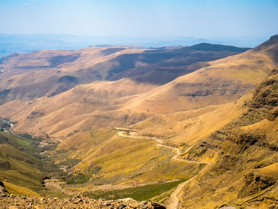 The Sani Pass road zigzagging down through the golden Lesotho highlands
