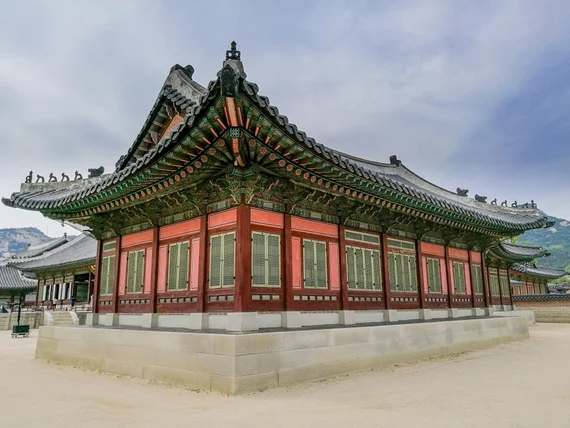 Ornate palace building with green roof tiles and red pillars