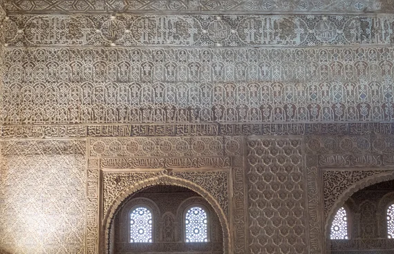 Carved stucco walls with light filtering through lattice windows