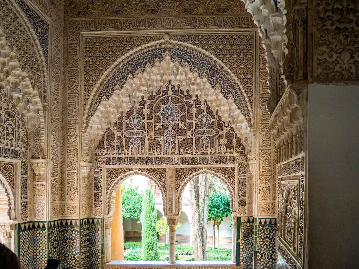Ornate archway with intricate tilework and carvings in the Nasrid Palaces