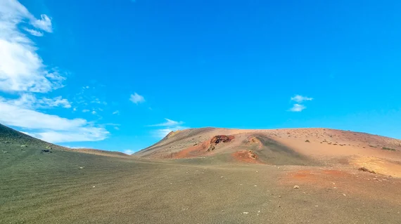 Colorful volcanic hill with green, orange, and red bands