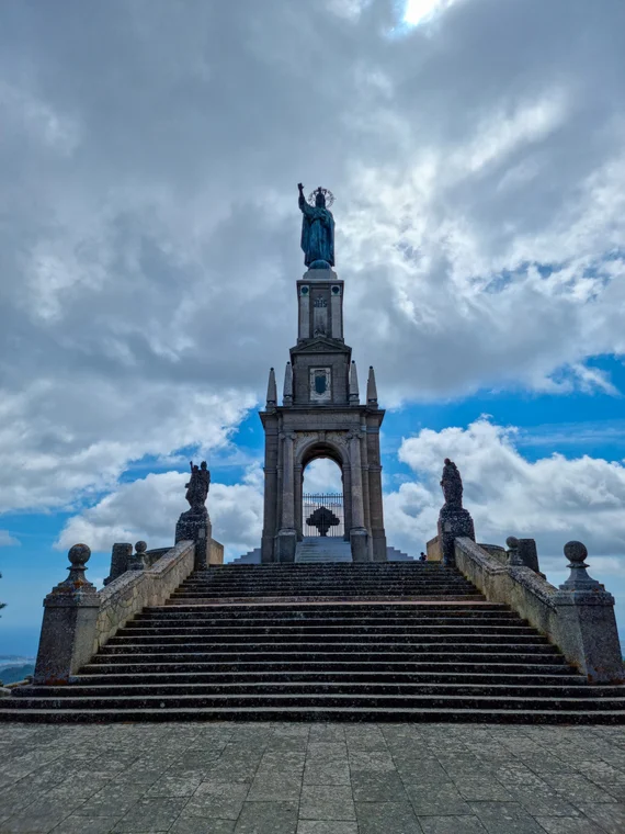 Stone monument with statue on summit, dramatic staircase