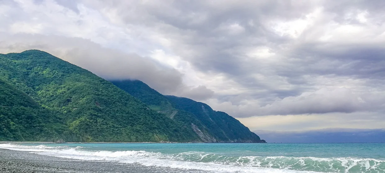 Dongao Beach with mountains rising behind