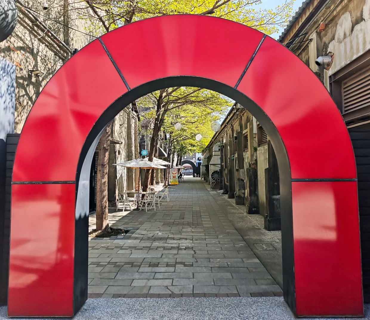 A red arch framing the old warehouse alley